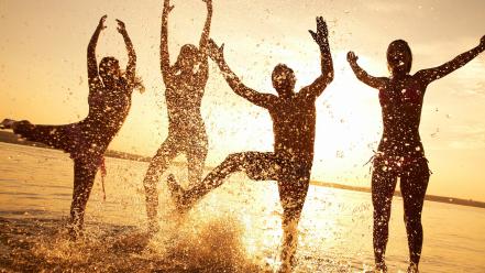 Sunset silhouettes sunlight dancing fun splashes beach wallpaper